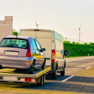 car being towed by recovery van